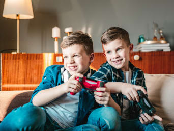 Videogames voor kinderen – Twee jongens spelen samen met de console.