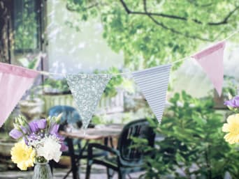 Addobbi festa in giardino: festone fai da te con bandierine in tessuto per decorare il giardino per una festa.