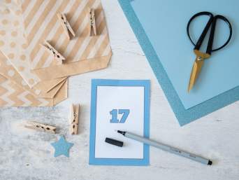Geschenk 18. Geburtstag basteln: Eine der 18 Karten liegt auf einem Tisch und ist bereit zum Beschriften und Verzieren. Geschenk 18. Geburtstag basteln: Eine der 18 Karten liegt auf einem Tisch und ist bereit zum Beschriften und Verzieren.