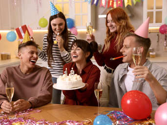 18. Geburtstag Ideen: Freunde feiern gemeinsam in der Küche den 18. Geburtstag ihrer Freundin.