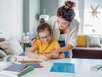Fare i compiti divertendosi: madre aiuta la figlia a fare i compiti.
