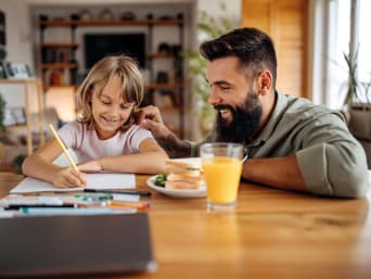Motivación para estudiar y aprender: un padre felicita a su hija por hacer los deberes.
