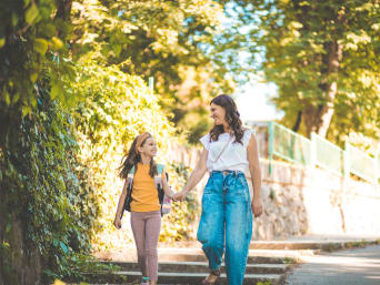Eerste schooldag na de zomervakantie - moeder en dochter wandelen naar school.