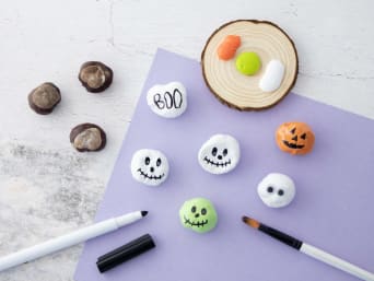 Halloween knutselen met kinderen: maak kleine spookjes en pompoenen van kastanjes.