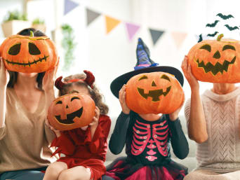 Costumbres de Halloween: familia disfrazada con farolillos hechos con calabazas.