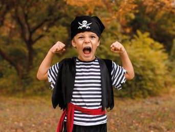 Maak je eigen piratenkostuum voor kinderen: jongen in zelf gemaakte halloweenkostuum.