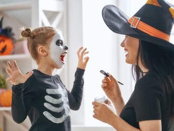 Trucco di Halloween per bambini fai da te: una bambina ha un make-up spaventoso fatto dalla mamma.