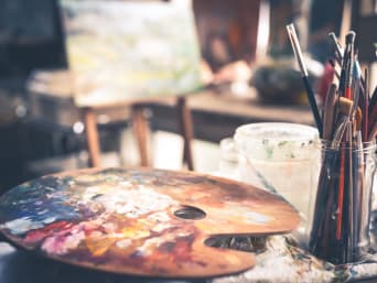 Malen für Anfänger: Farbpalette mit Pinseln auf einem Tisch.