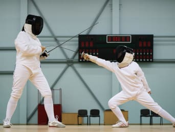 Scherma regole: una bambina e il suo allenatore si allenano in una palestra. Scherma regole: una bambina e il suo allenatore si allenano in una palestra.