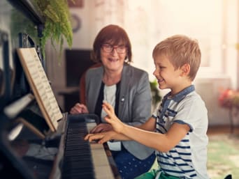 Muziekinstrumenten kinderen – Kleine jongen bij de pianoles.