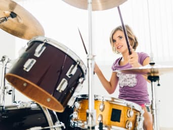 Zajęcia muzyczne dla dzieci – dziewczynka podczas nauki gry na perkusji. 