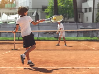Kinderen trainen op de tennisbaan.
