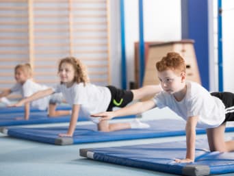Kinderen trainen op gymnastiekmatten.