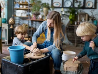 Une mère fait de la poterie avec ses deux enfants.