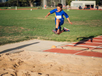 Clases de atletismo para niños: un niño haciendo salto de longitud.