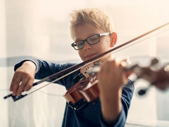 Activité extra-scolaire : un enfant apprend à jouer du violon.