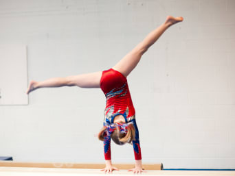 Gimnasia para niños: una niña hace una acrobacia.