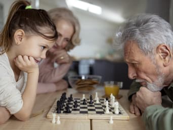 Schach lernen Kinder – Mädchen spielt gegen ihren Grossvater.