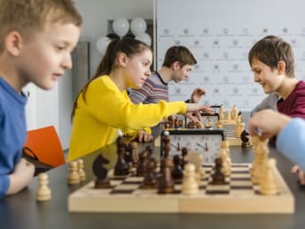 Gra w szachy dla dzieci – dziewczęta i chłopcy podczas zajęć w szkółce szachowej. 