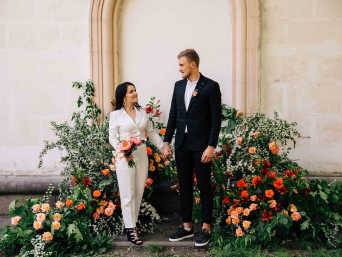 Außergewöhnliche Hochzeitskleider: Braut im weißen Hosenanzug Hand in Hand mit dem Bräutigam.