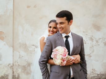 Costumbres de bodas: una pareja de novios con un ramo de flores.