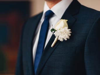 Bräutigam-Anzug – Nahaufnahme des Blumenschmucks am Anzug.