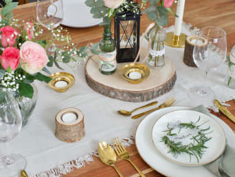 Ozdoby weselne – pomysły na dekoracje ślubne z elementami drewna i szkła, utrzymane w zielonej tonacji kolorystycznej.