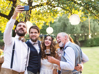 Outfit invitato matrimonio: invitati al matrimonio fanno un selfie con gli sposi in giardino