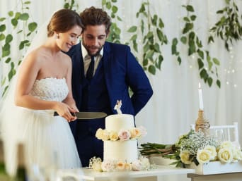 Trouwerij kosten per gast voor catering: bruidspaar snijdt de taart aan. 