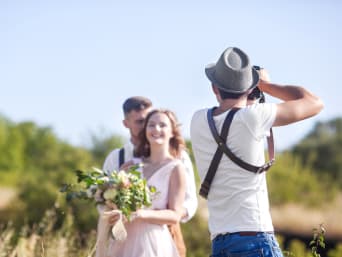 Jak zaoszczędzić na weselu? Zdjęcie pary młodej wykonuje ich przyjaciel.