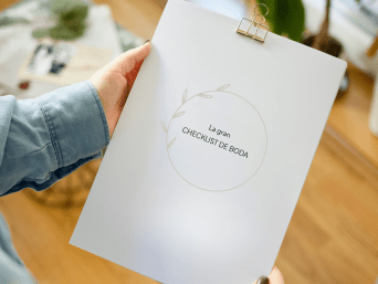 Cómo organizar una boda: una mujer sostiene una checklist para planificar una boda. Cómo organizar una boda: una mujer sostiene una checklist para planificar una boda.