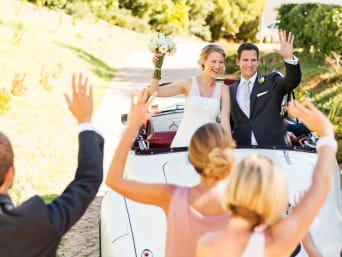 Wedding planning made easy: a bride and groom sitting in a wedding car.