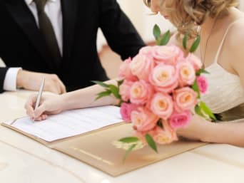 Standesamtliche Trauung: Brautpaar unterzeichnet die Heiratsurkunde im Standesamt.