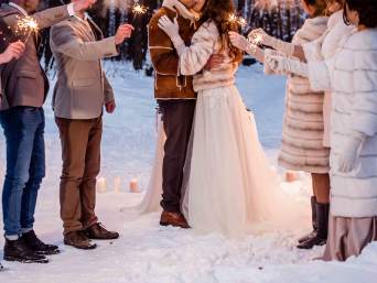 Hochzeit im Winter: Brautpaar und Gäste mit Wunderkerzen im Schnee. Hochzeit im Winter: Brautpaar und Gäste mit Wunderkerzen im Schnee.
