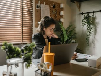 A woman working in her home office using sustainable office supplies and appliances.