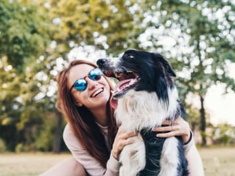 Quel chien est fait pour moi ? Une maîtresse et son chien jouent au parc.  