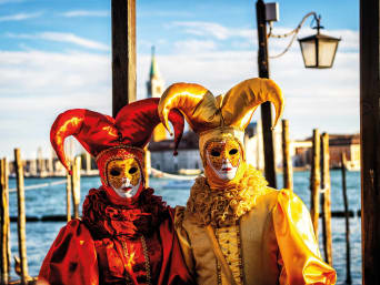 Zwyczaje karnawałowe – dwie postacie w kolorowych maskach podczas karnawału w Wenecji.