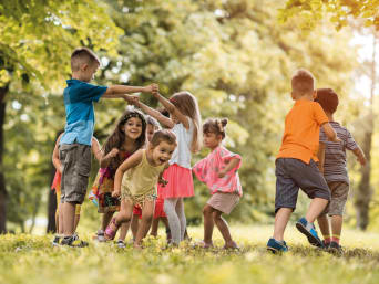 Kinder spielen zusammen im Außenbereich des Kindergartens.
