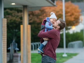 Premier jour de crèche : un père dit au revoir à son enfant en l’embrassant.