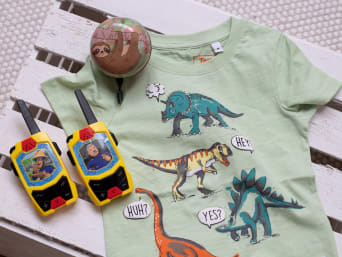 Regalos de cumpleaños para niños: un timbre de bicicleta, unos walkie-talkie y una camiseta con estampado de dinosaurios.