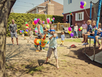 Juegos para cumpleaños: un grupo de niños juega y se divierte en una fiesta en un jardín.