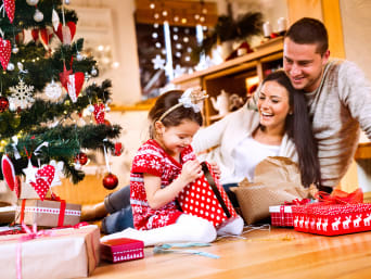 Regali per bambini a Natale: una famiglia spacchetta i regali di Natale.