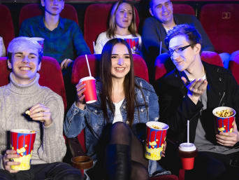 Idée cadeau de Pâques pour adolescents : des amis sont au cinéma et mangent des snacks.