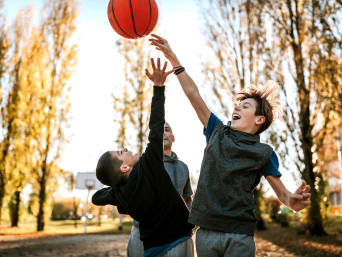 Regalo bambini 10-12 anni: bambino gioca a basket con gli amici.