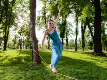 Cadeau voor 12-jarigen: jong meisje balanceert op een slackline in het park.
