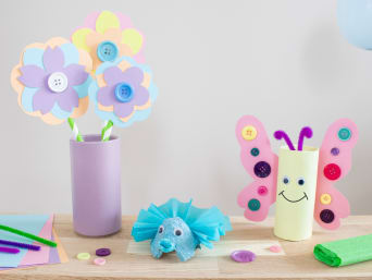 Basteln zum Kindertag: Fertig gebastelte Blumen und Schmetterlinge liegen auf einem Tisch.