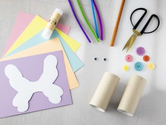 Dzień Dziecka praca plastyczna – materiały potrzebne do wykonania papierowych motyli leżą gotowe na stole.