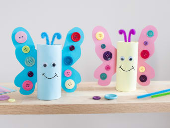 Výroba papírových motýlů: Na stole jsou barevně zdobení motýli ke Dni dětí.