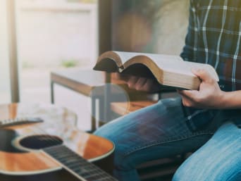 Regali di Cresima: un teenager con una chitarra legge la bibbia.