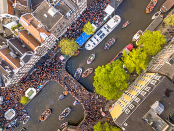 Koningsdag – Mensen gaan massaal oranje en rood-wit-blauw verkleed over straat